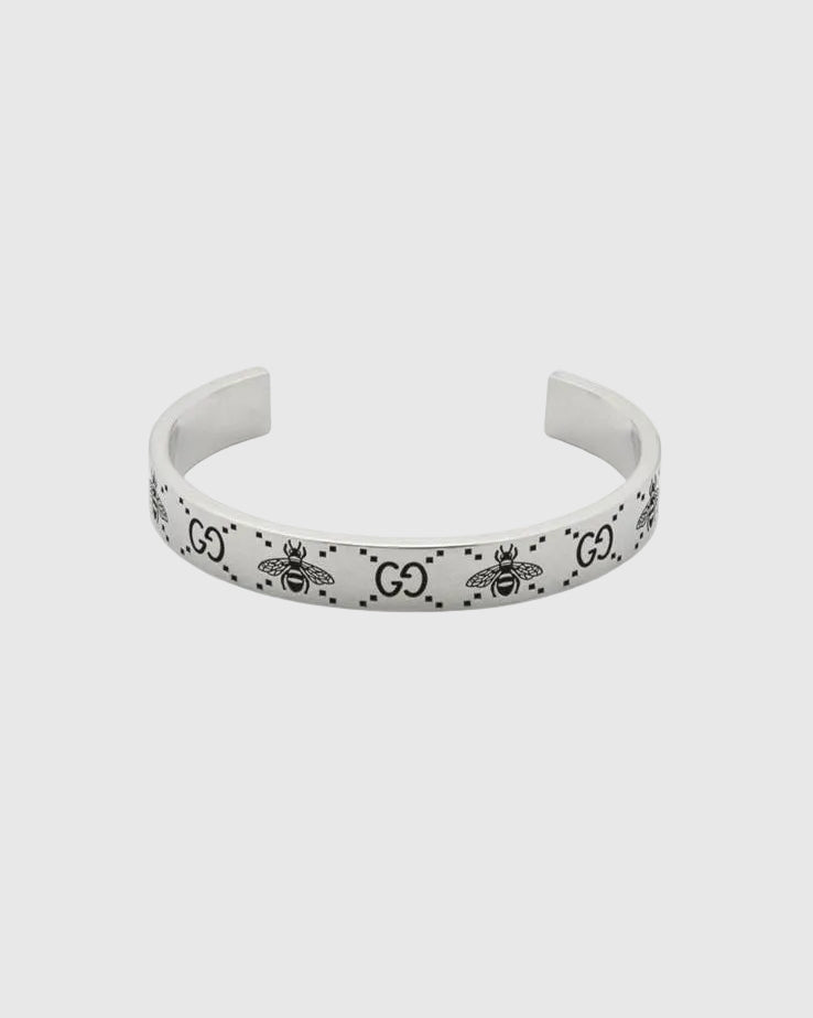 Elegant open cuff silver bracelet with engraved logo pattern, luxury minimalist bangle for women, high-end jewelry close-up