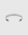 Elegant open cuff silver bracelet with engraved logo pattern, luxury minimalist bangle for women, high-end jewelry close-up