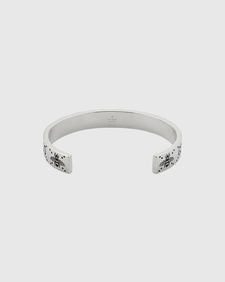Elegant open cuff silver bracelet with engraved logo pattern, luxury minimalist bangle for women, high-end jewelry close-up