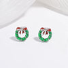 A collection of children's jewelry featuring studs in the shapes of cherries, strawberries, and festive trees, with a white and green color scheme.