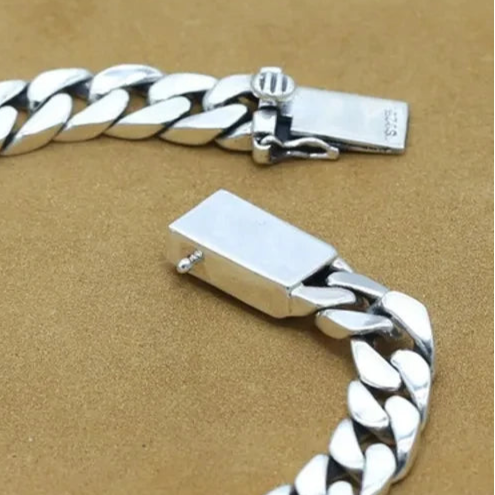 A sterling silver bracelet with a lock-inspired design on a textured background, showcasing the VELTORI brand hallmarks.