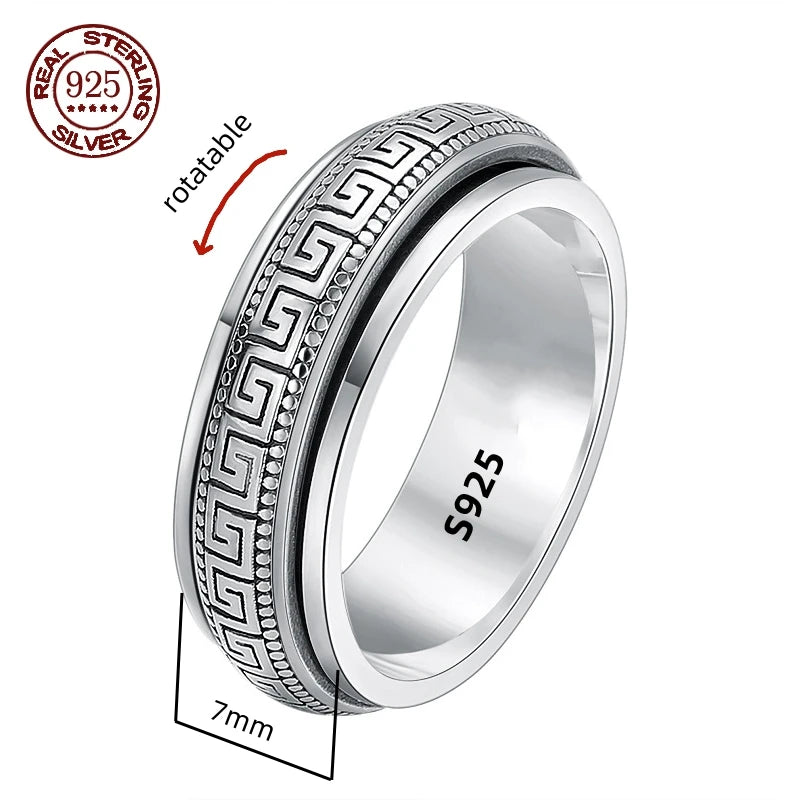 A silver spinner ring with Great Wall-inspired engravings on a double-layered band, displayed on a wooden texture background.