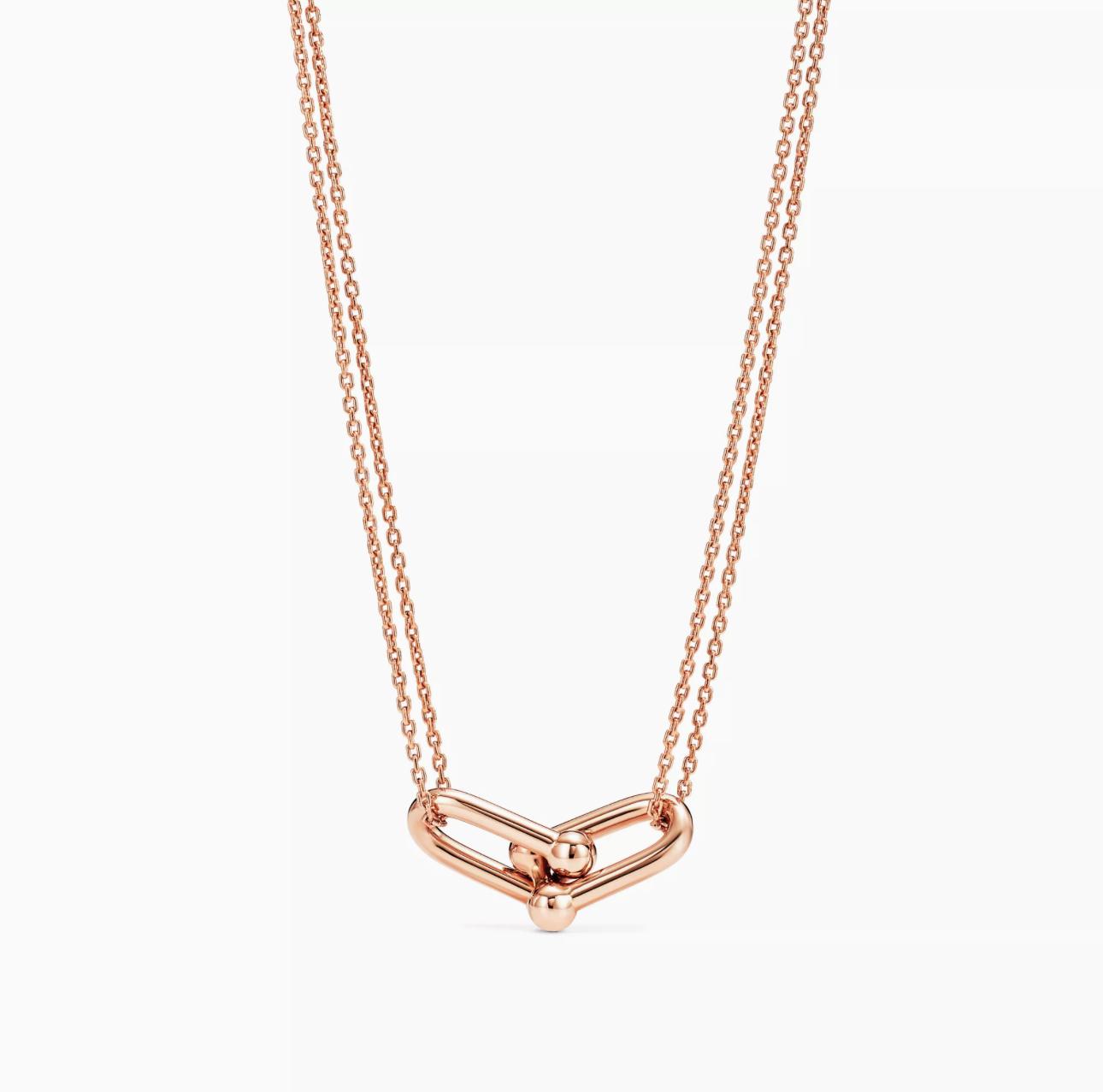 Rose gold gold double link necklace with a unique design on a white background