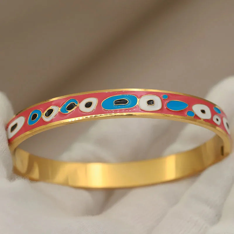 Gold bracelet with colorful pattern on a beige background
