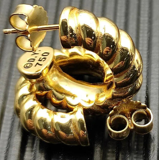 Gold spiral earring on a textured gray background