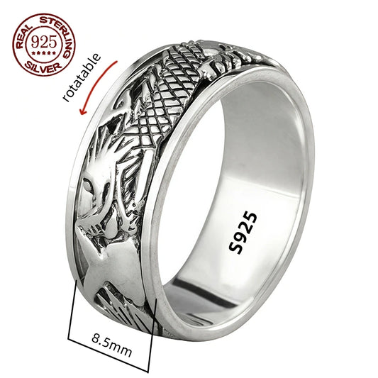 A silver spinner ring with Great Wall-inspired engravings on a double-layered band, displayed on a wooden texture background.