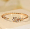 boucheron gold bracelet with feather design on a white background
