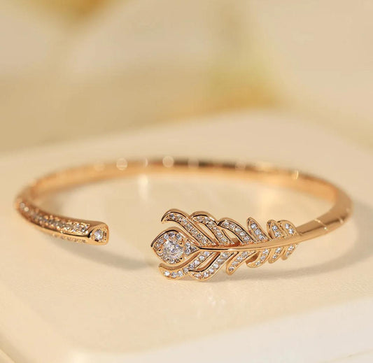 boucheron gold bracelet with feather design on a white background