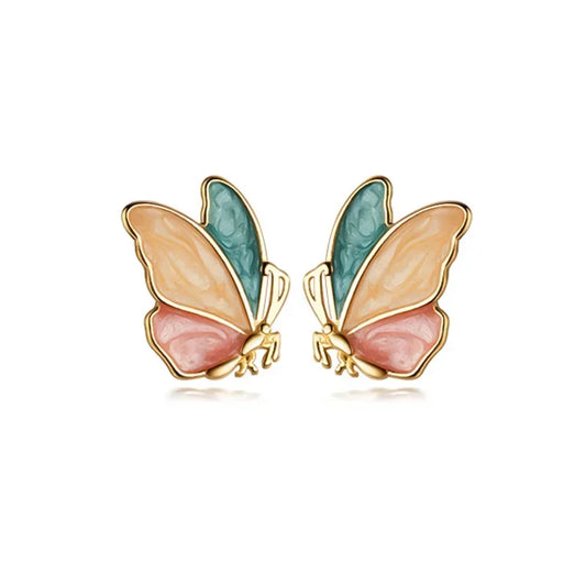A pair of colorful butterfly stud earrings crafted from real 925 sterling silver, displayed on a beige fabric surface.