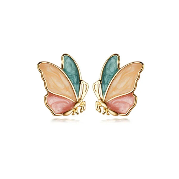 A pair of colorful butterfly stud earrings crafted from real 925 sterling silver, displayed on a beige fabric surface.