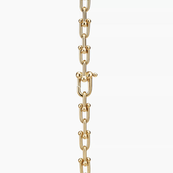 Gold chain Horsebit link design necklace on a white background