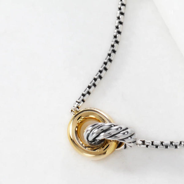 Necklace with a gold and silver pendant on a white background