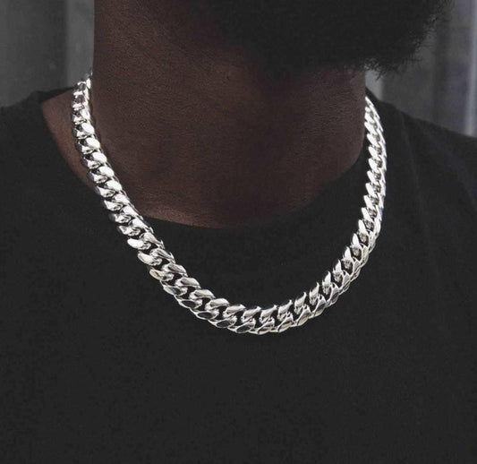 Silver chain necklace worn by a person on a black background