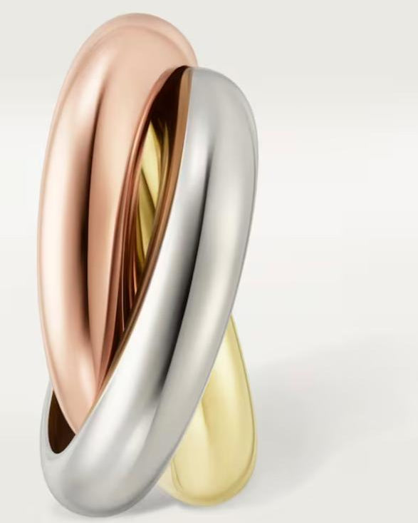 Close-up of the classic tri-color earrings demonstrating the fluid, seamless rolling mechanism of the three intertwined metallic bands.
