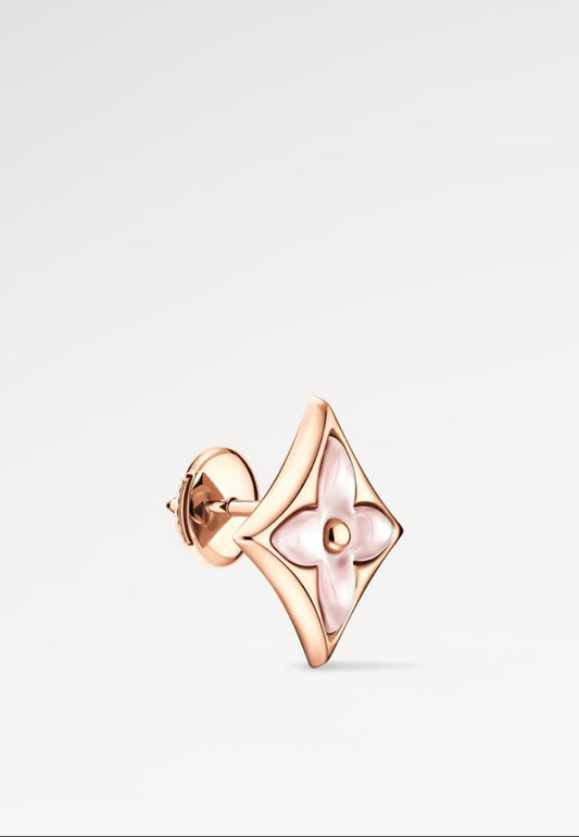 Rose gold earring on a light gray background