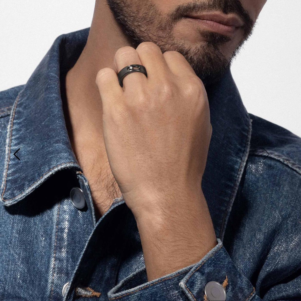 Man wearing a black ring on his finger with a denim jacket