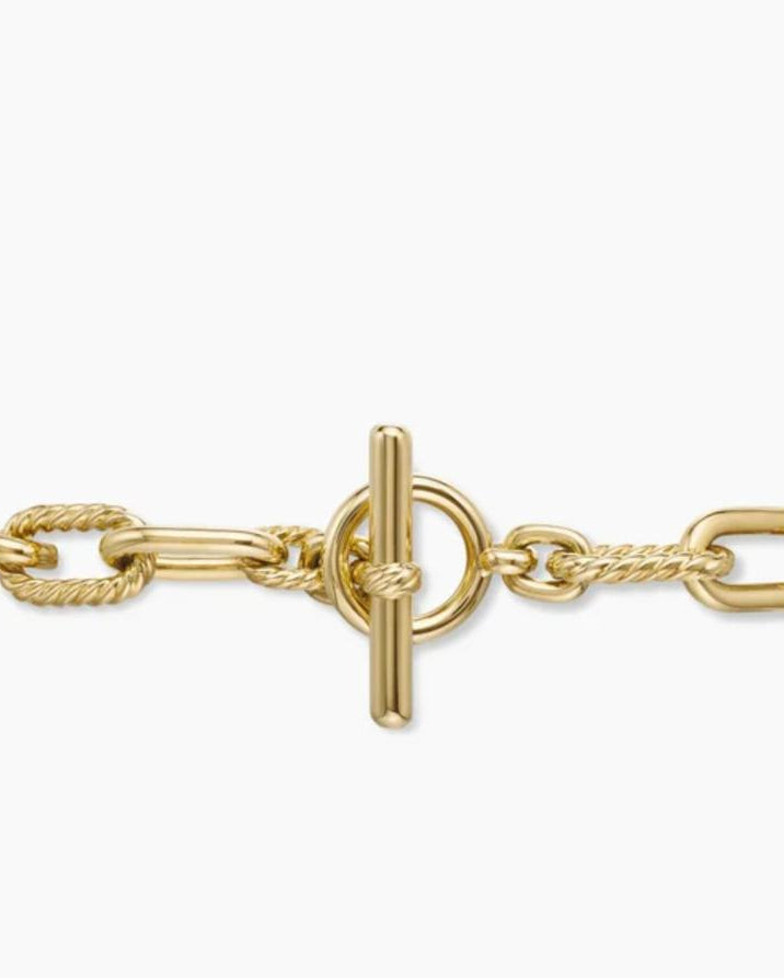 Extreme close-up of the front-facing toggle clasp on the gold chain, showcasing the T-bar and circular loop.