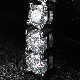 Macro close-up of Lumora Radiance moissanite stones showing brilliant cut and prong setting in 925 silver with 18K white gold plating