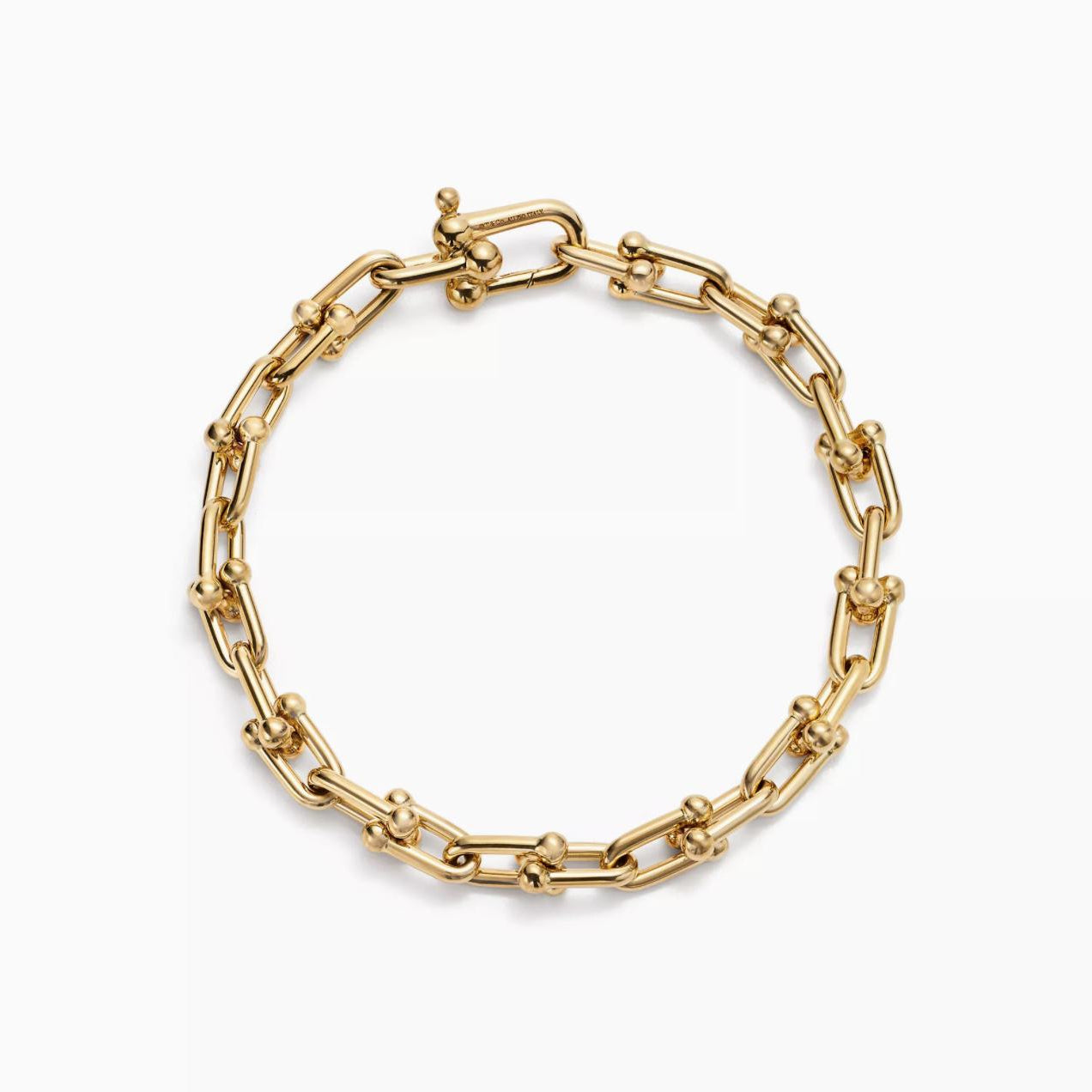 Gold horsebit link chain bracelet on a white background