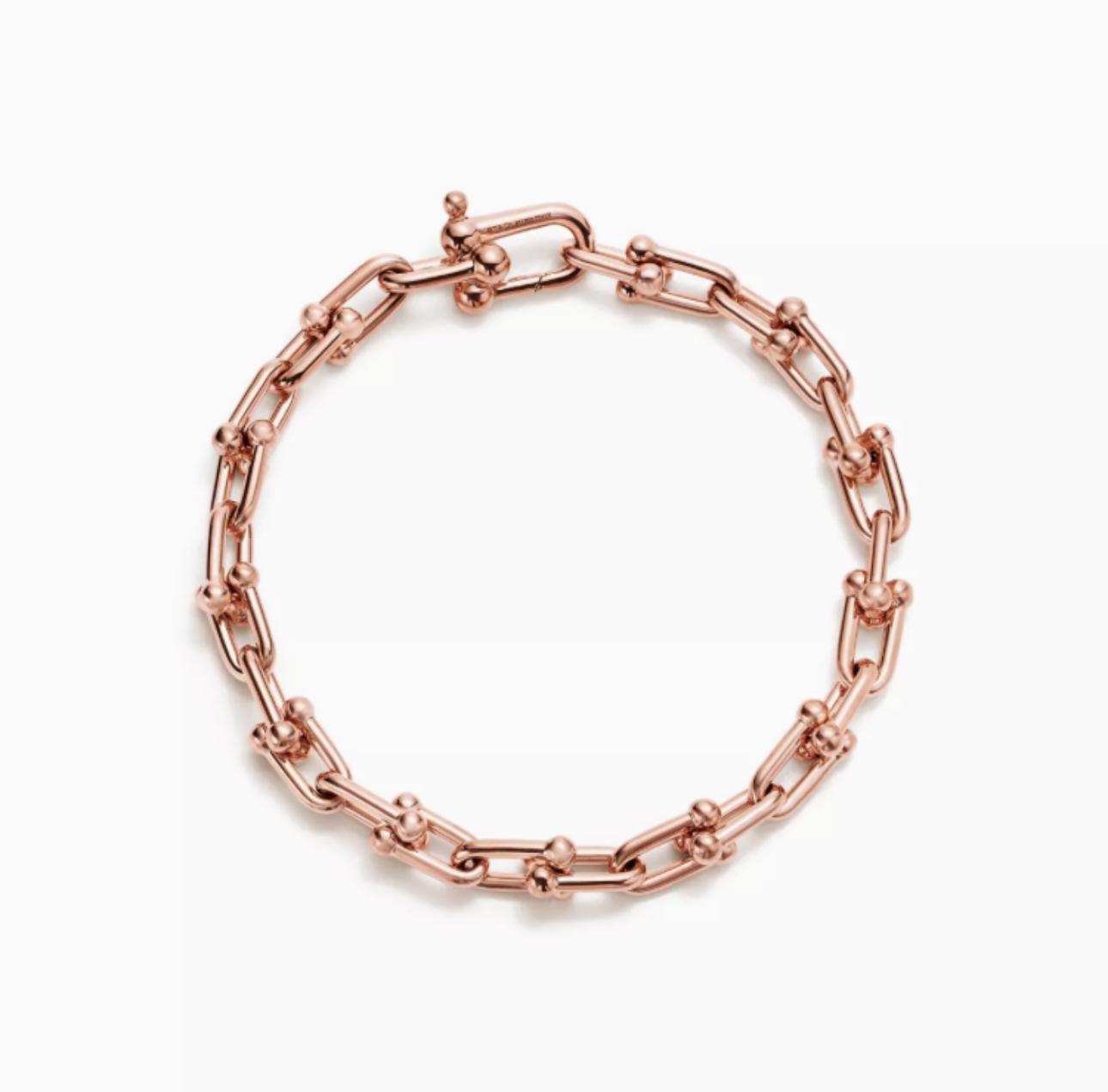 Rose gold horsebit link chain bracelet on a white background