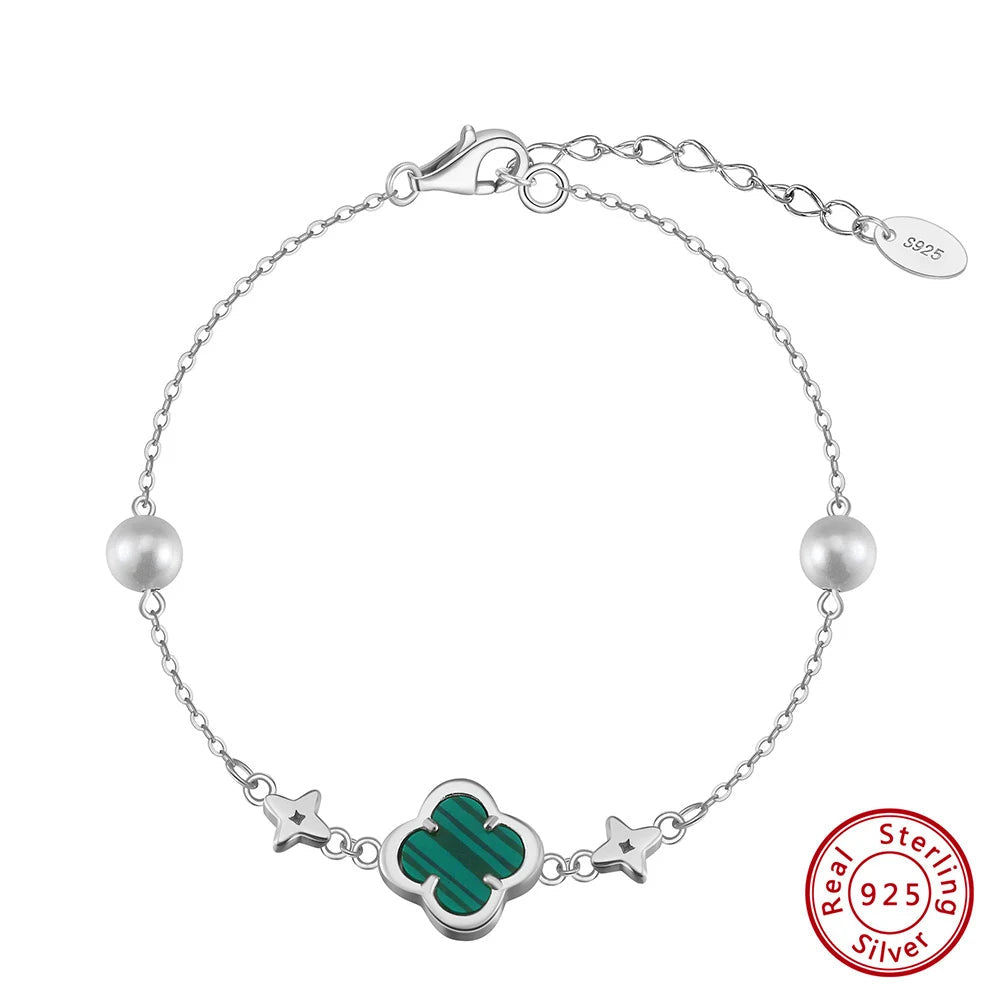 Silver bracelet with green clover charm and pearl beads on a white background, featuring Orsa Jewels branding.