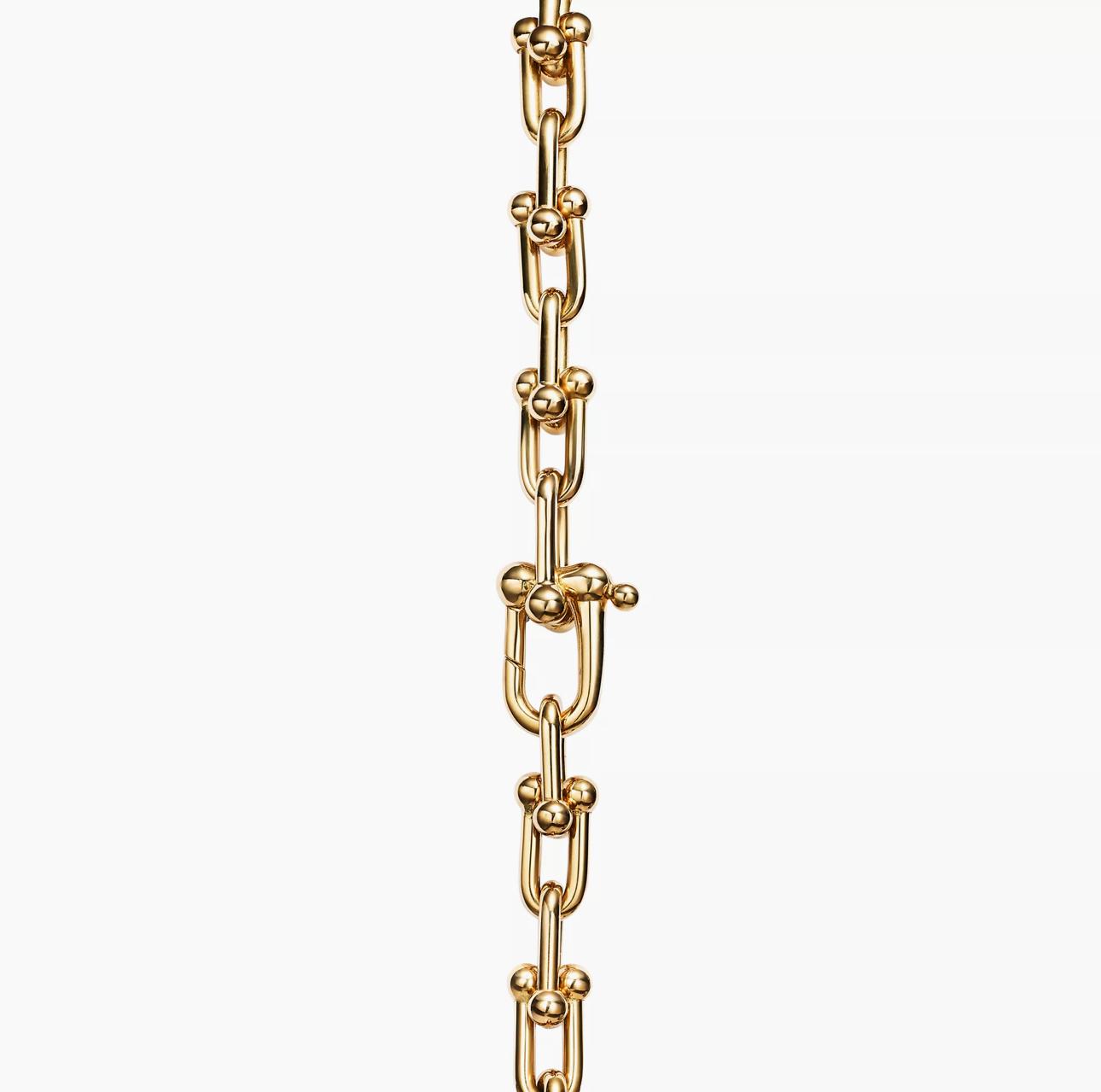Gold horsebit link chain bracelet on a white background