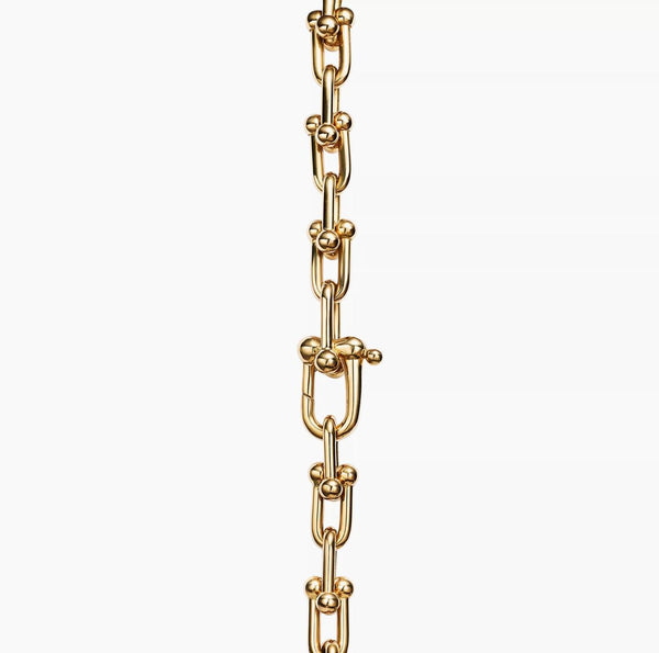 Gold horsebit link chain bracelet on a white background