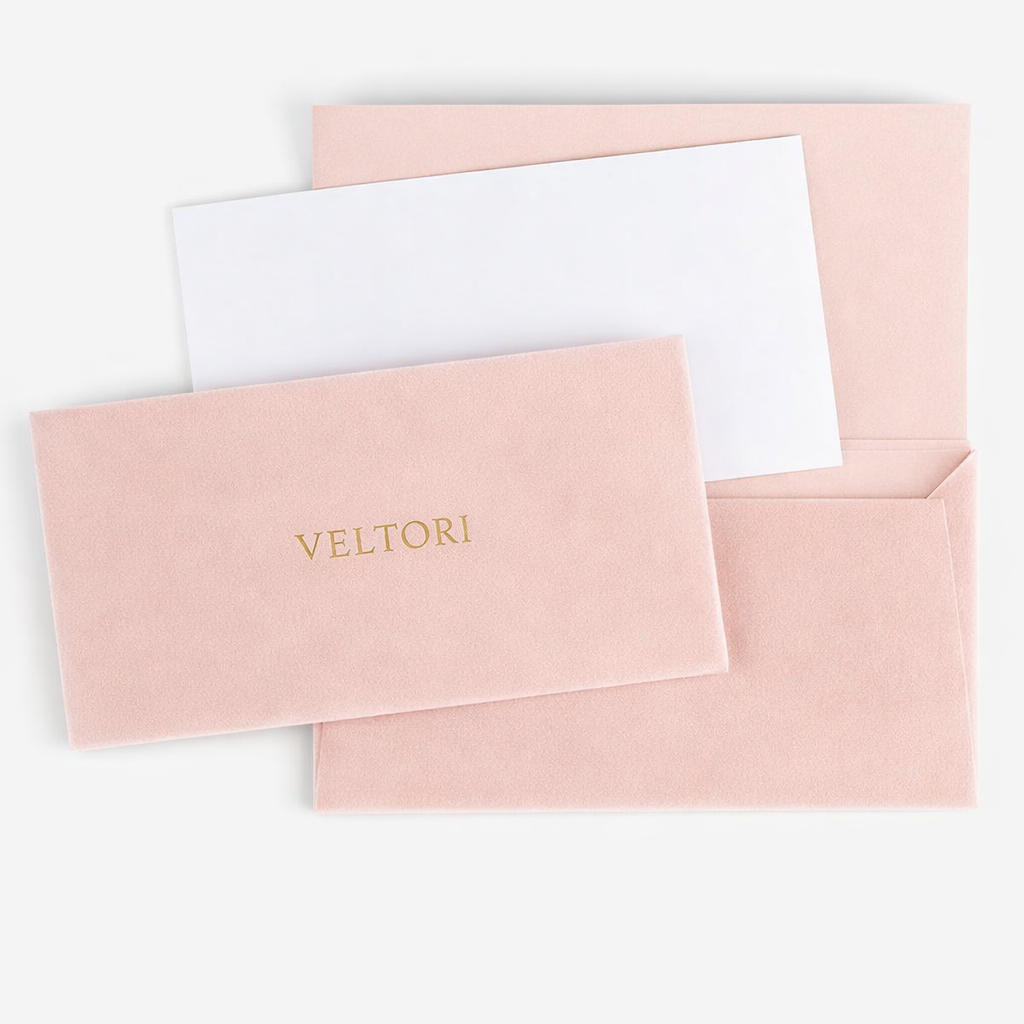 VELTORI luxury packaging – blush pink velvet envelope with champagne gold logo