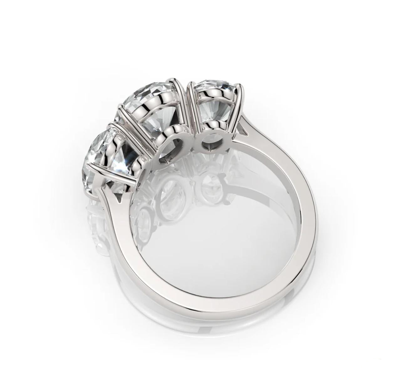 Silver ring with three diamond-like stones on a white background