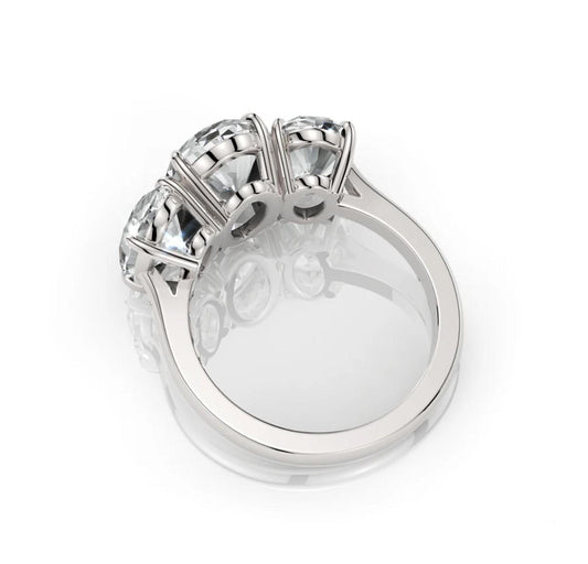 Silver ring with three diamond-like stones on a white background