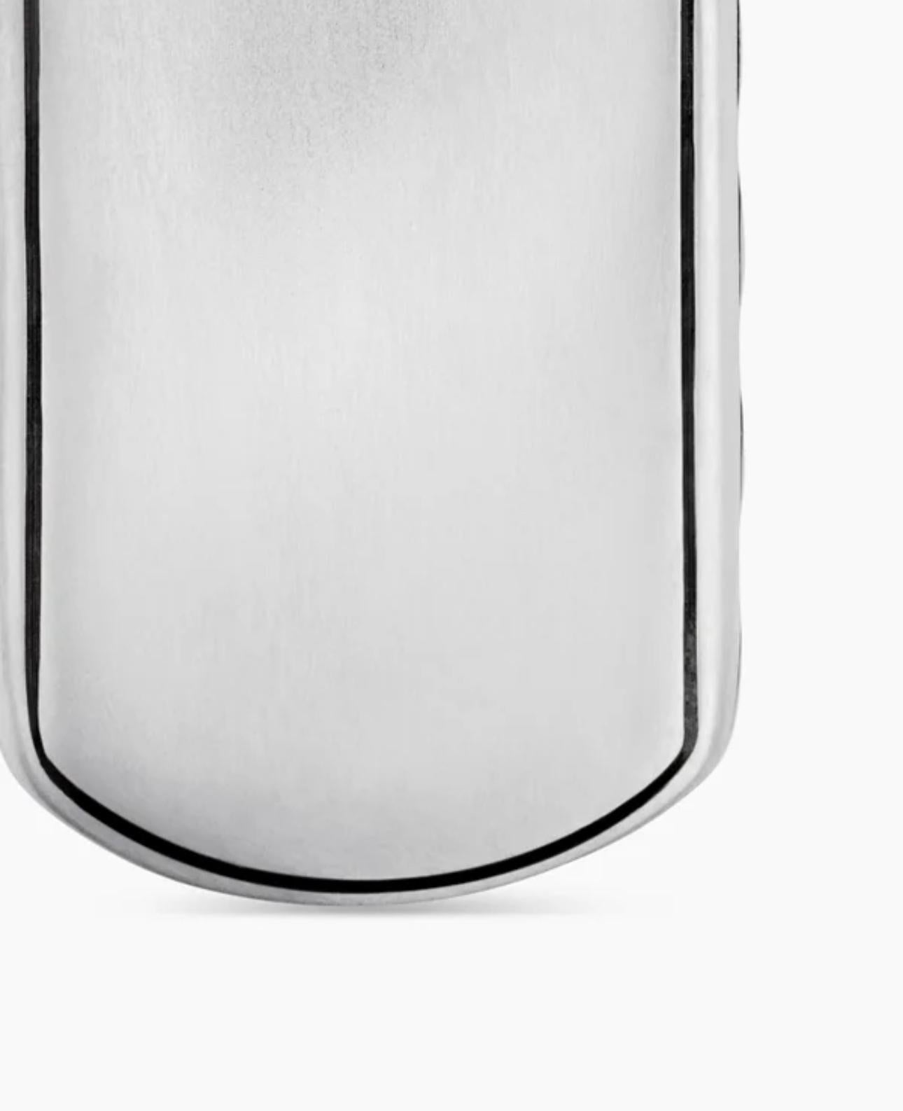 Close-up of the smooth sterling silver tag pendant back, featuring a polished surface with soft curved edges.