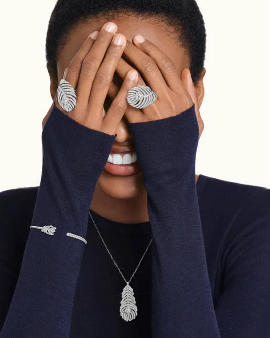 A luxury editorial photo of a model wearing the L’Éthérée peacock feather bracelet and matching diamond rings, showcasing a quiet luxury aesthetic.