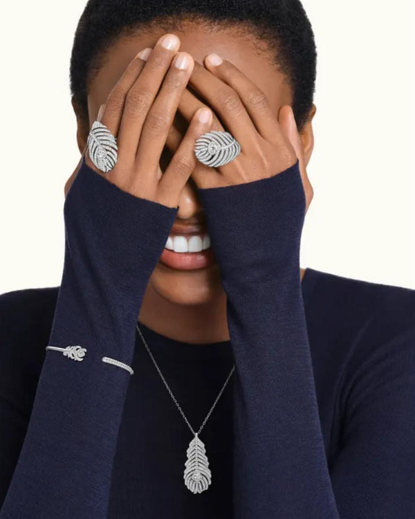 A luxury editorial photo of a model wearing the L’Éthérée peacock feather bracelet and matching diamond rings, showcasing a quiet luxury aesthetic.