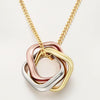 Three interlocking heart-shaped pendants on a gold chain against a light background