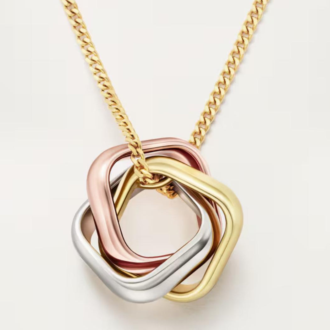 Three interlocking heart-shaped pendants on a gold chain against a light background