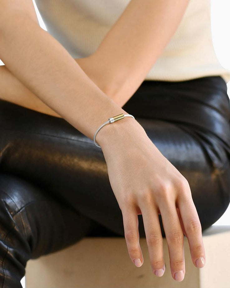 Person wearing a bracelet on a plain background
