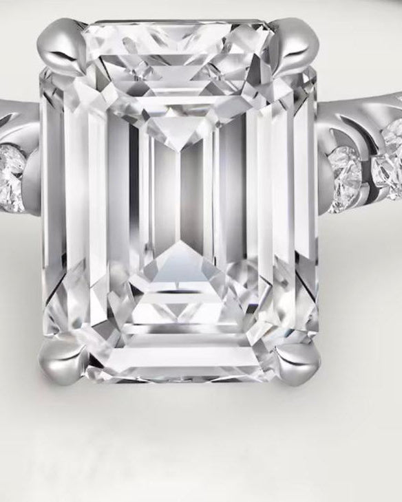 Aerion Lumière 4-carat Emerald Cut Moissanite Solitaire Ring with 4-claw prong setting and U-Cut Pavé band, showcasing D-color VVS1 brilliance on a white background.