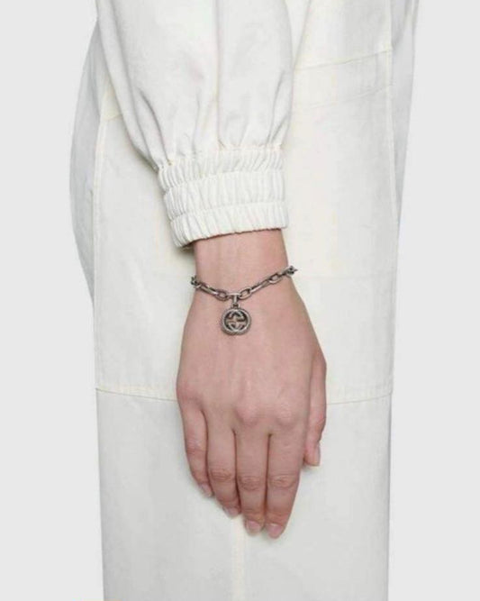 Lifestyle shot of a model wearing the Aerion Marmont 925 silver chunky chain bracelet with an oxidized monogram pendant on the wrist.
