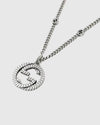 Close-up detail of the sculpted interlocking monogram charm with a twisted rope motif and antiqued oxidized finish.