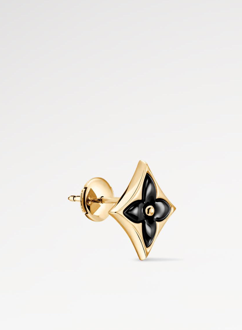 Gold earring with black center on a white background