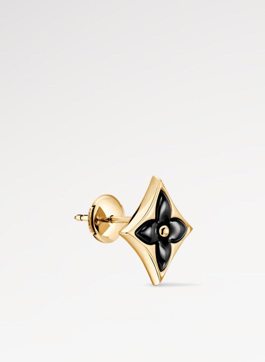 Gold earring with black center on a white background