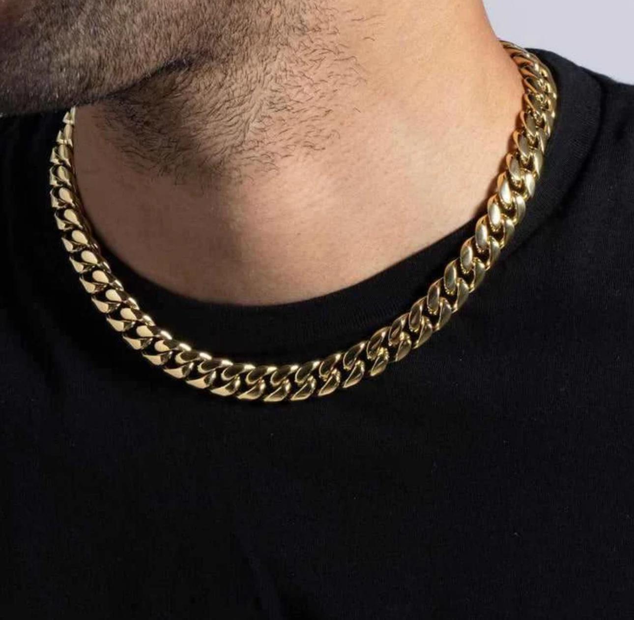 Gold chain necklace worn by a person on a black background