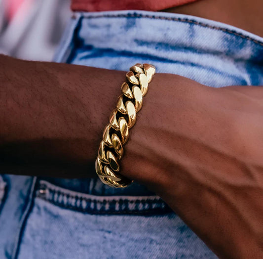 Gold chain bracelet on a wrist with a blurred background