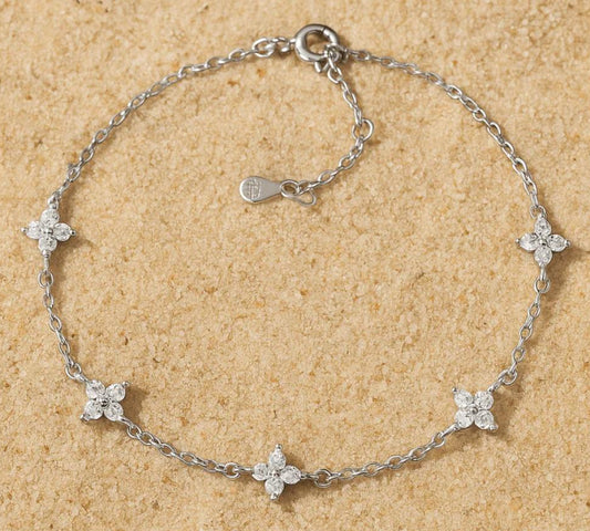 Silver bracelet with floral designs on a beige background