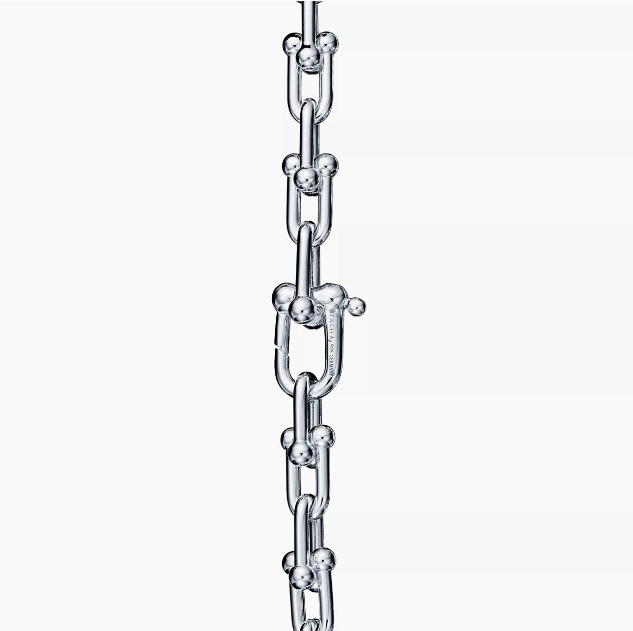 Silver chain with push-in clasp mechanism on a white background