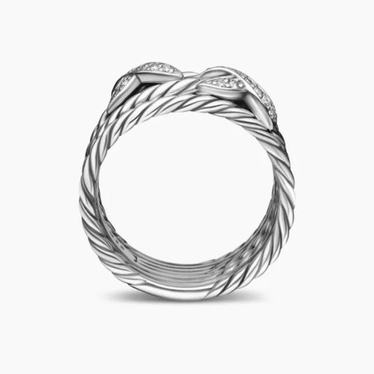Silver ring with intricate design on a white background
