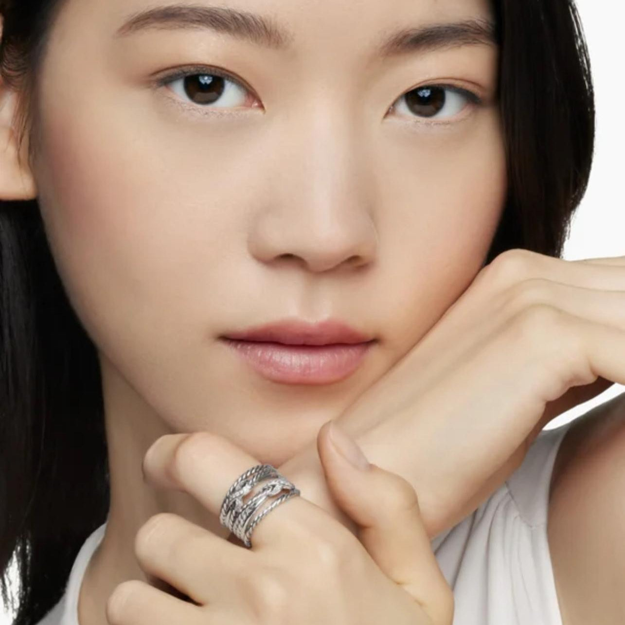 Close-up of a person wearing a ring with a white background