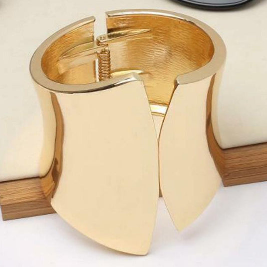 Gold bracelet on a white surface in the background