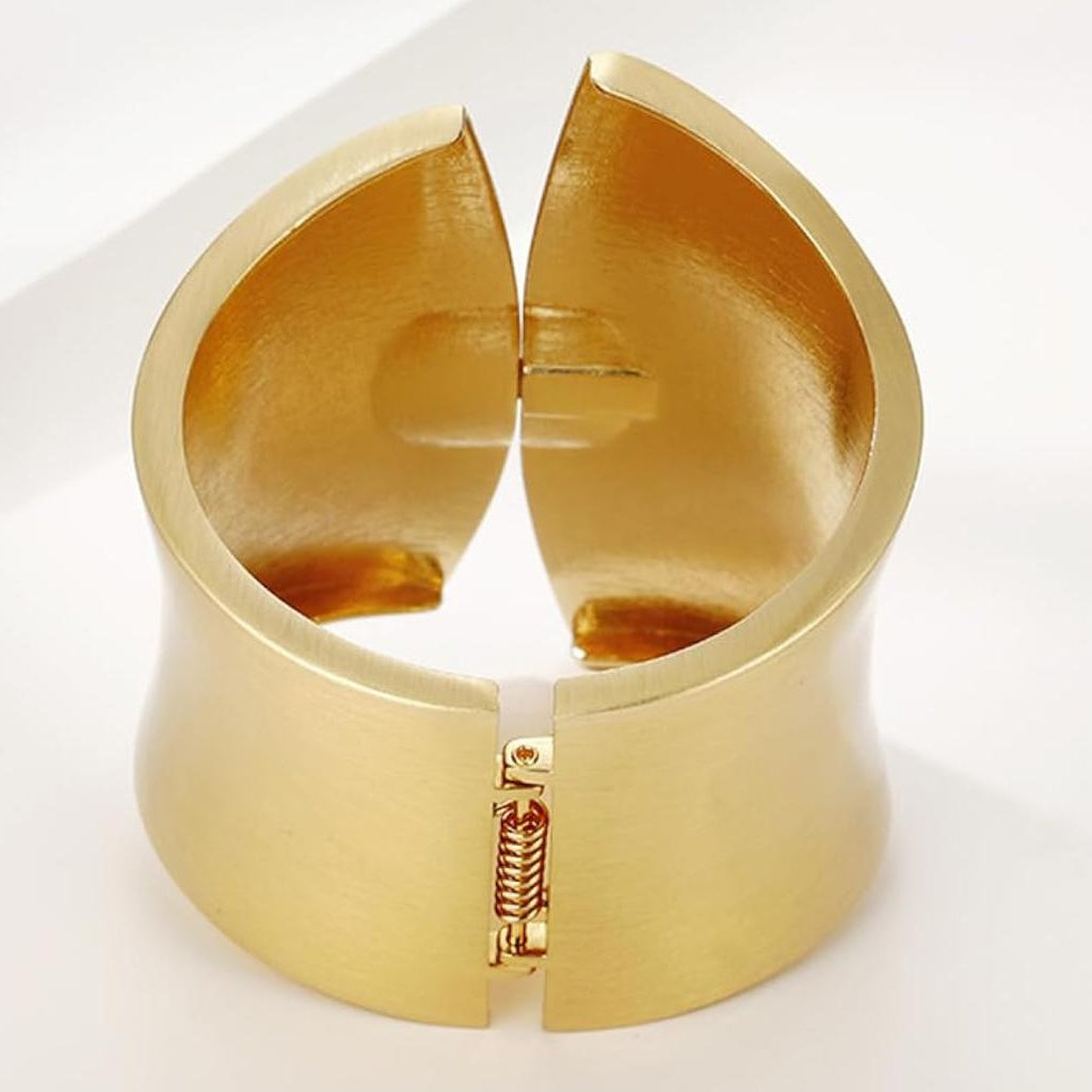 Gold cuff bracelet on a white background