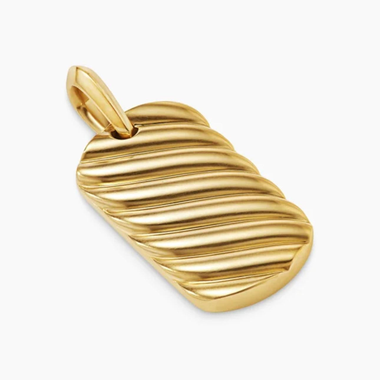Angled view of a gold pendant with diagonal cable-inspired grooves and a polished bail.